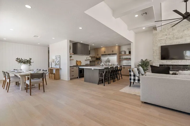 Open great room with kitchen island, dining table and stone fireplace in a Holmes nightly rental home