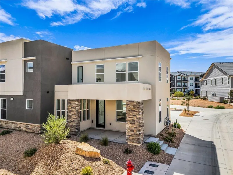 Two-story Holmes townhome with stone columns and covered entry in Desert Color